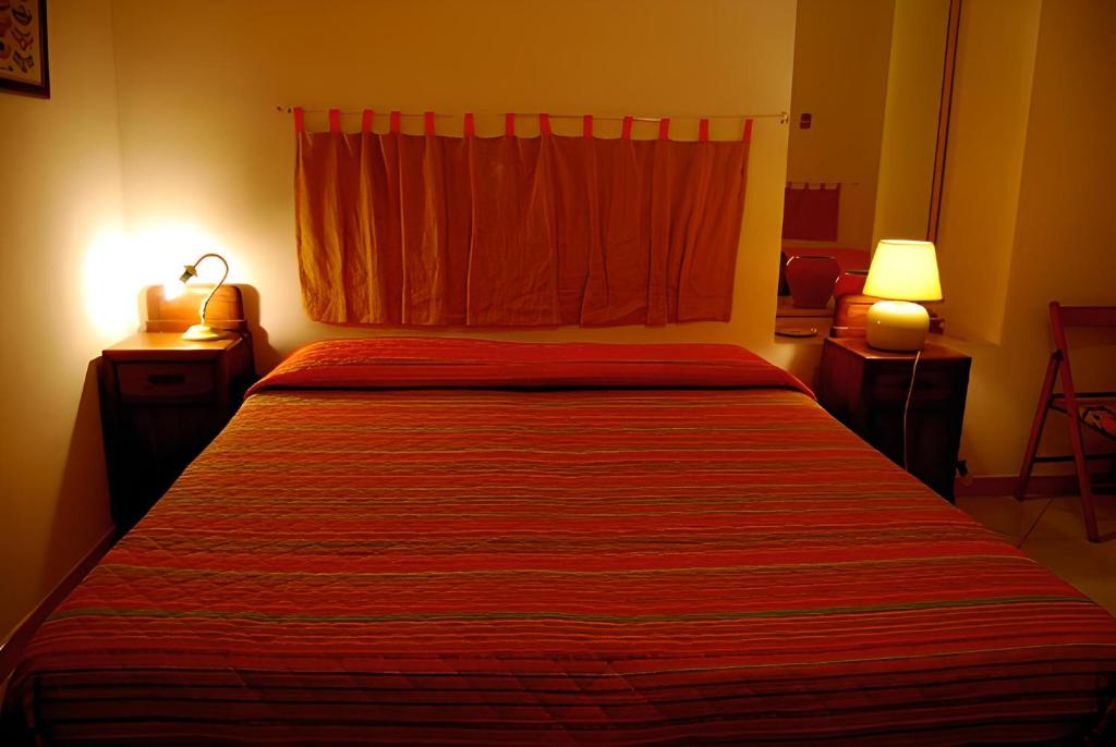焦约萨马雷阿Bed & Breakfast 5 Di Spade的一间卧室配有一张大床和红色的床罩
