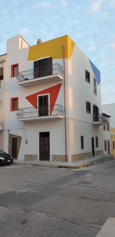 兰佩杜萨RgB_Apartments的一座白色和橙色的建筑,设有阳台