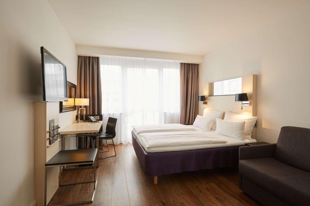 柏林库尔菲尔斯滕斯堪柏林酒店的酒店客房,配有床和沙发