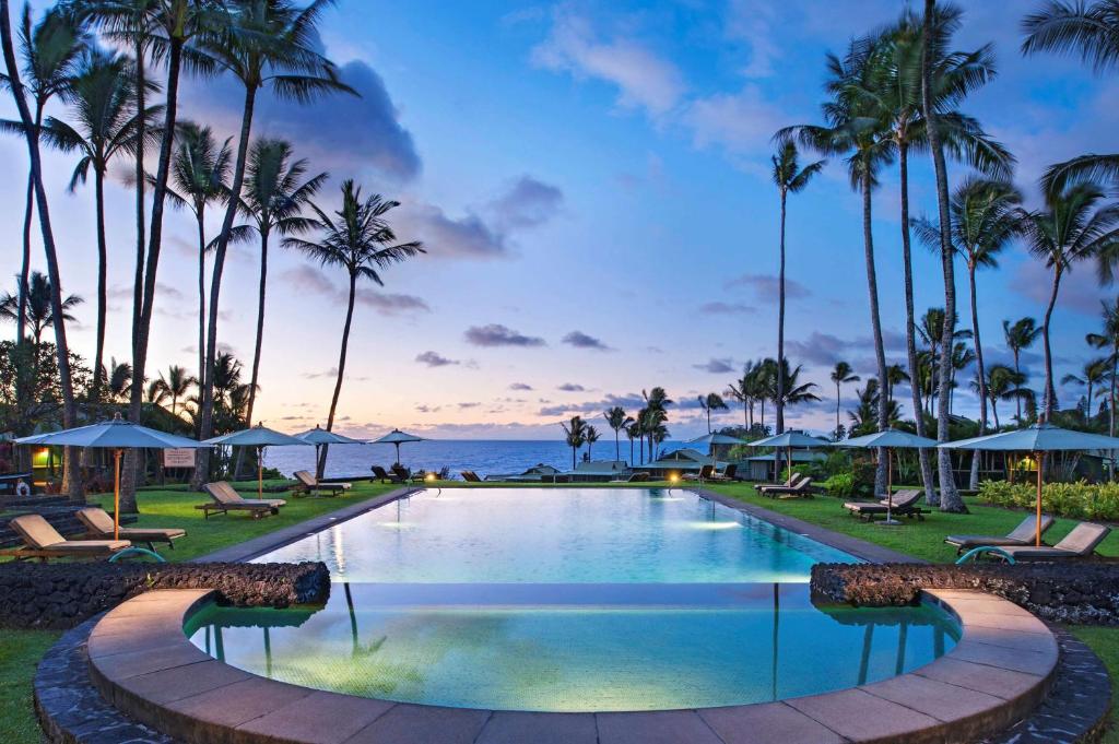哈纳Hana-Maui Resort, a Destination by Hyatt Residence的棕榈树和海洋度假村的游泳池