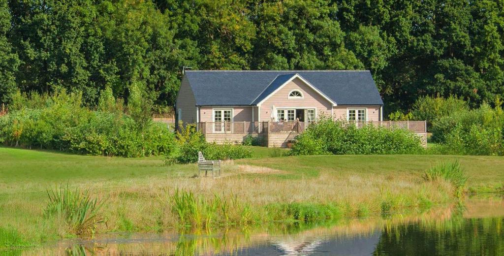 ChappelWoodbell Lodge的坐在湖边田野上的房屋