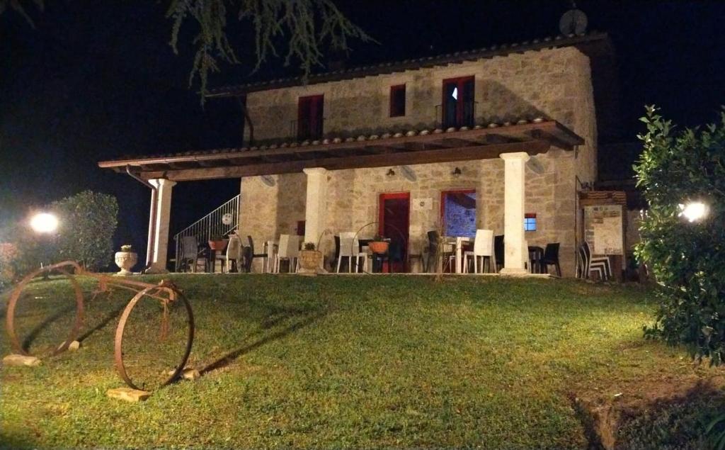 阿斯科利皮切诺B&B Mosca Bianca的石头房子,在晚上在草坪上摆放椅子