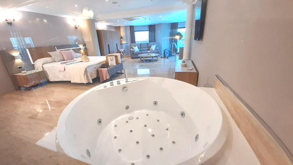 马里亚诺努埃瓦广场酒店的卧室内的白色大浴缸
