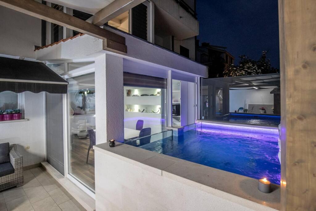 斯普利特Luxury apartment Martinis with pool的夜间在房子里的一个游泳池