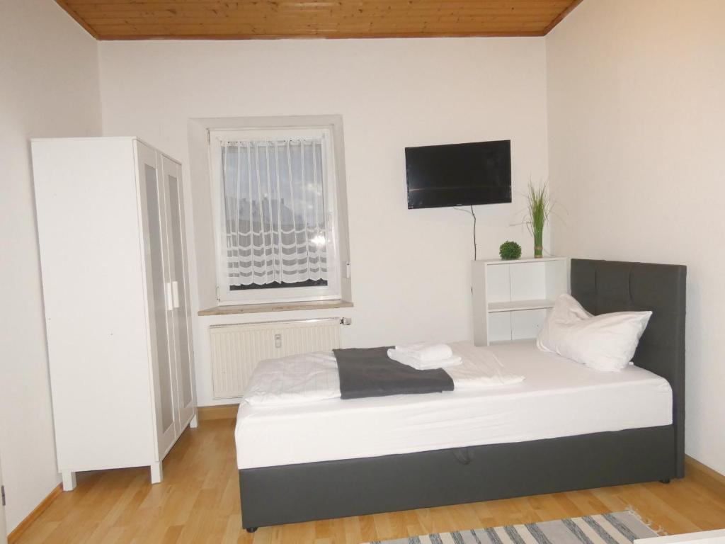 MoosbürgSUNNYHOME Monteurwohnungen und Apartments in Weiden的卧室配有一张床铺,墙上配有电视
