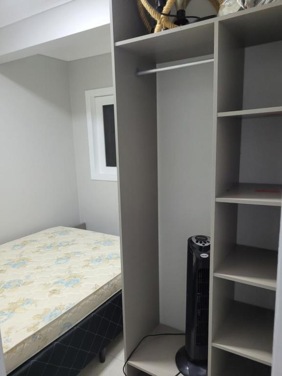 加罗帕巴NOVO LAR GAROPABA 2的一间卧室设有一张床和一个书架