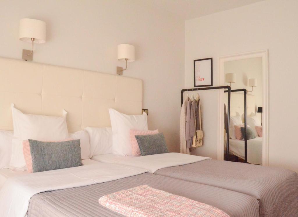 普韦布拉桑纳比亚卡洛斯V旅馆的卧室配有一张白色大床和镜子