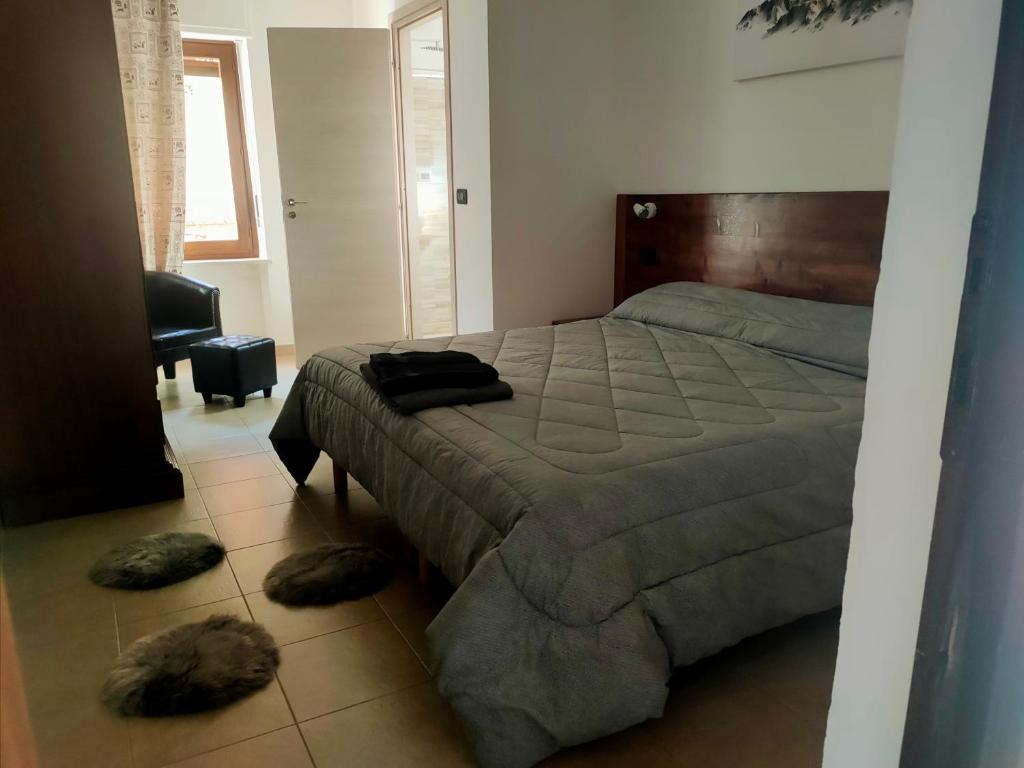奥斯塔Locanda mami的卧室配有一张带两个枕头的床,位于地板上