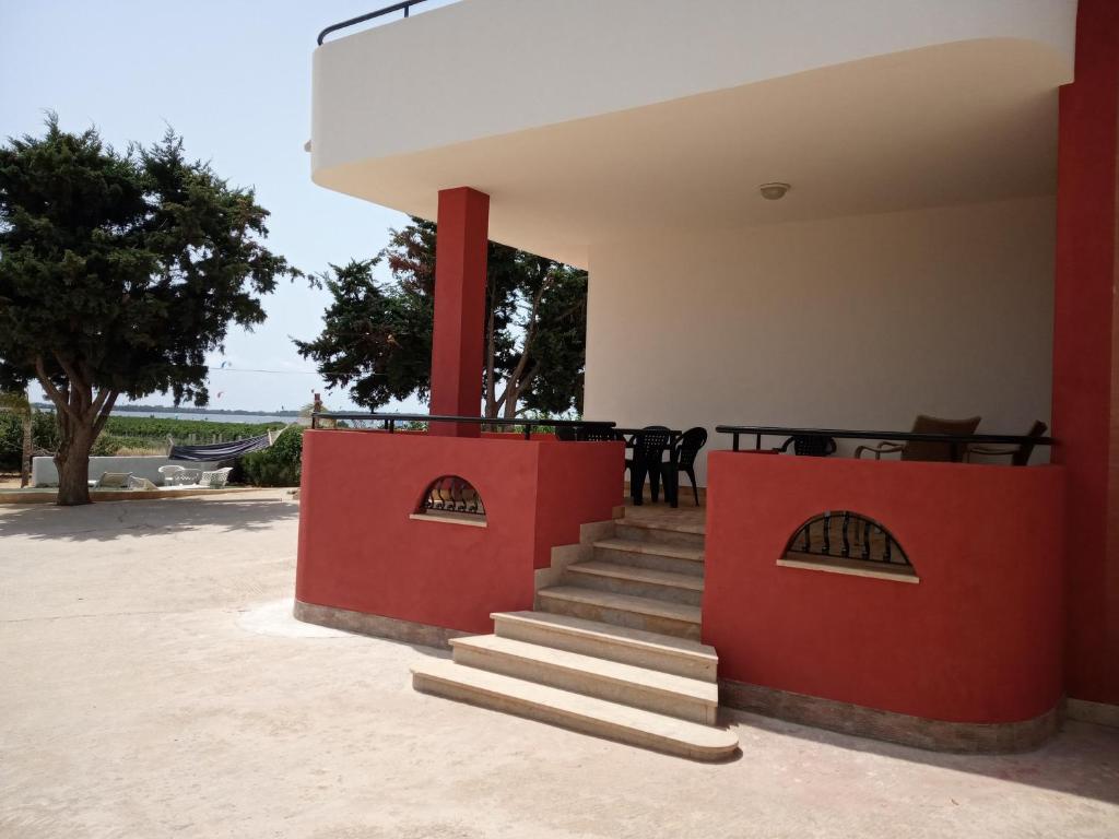 伯吉维奇Isole Dello Stagnone Apartaments的房屋设有红色的墙壁和景观楼梯