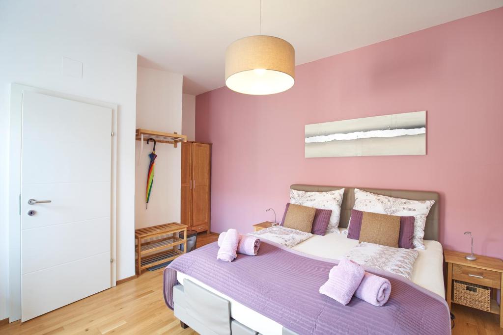 LinsbergGästezimmer Victoria的卧室设有粉红色的墙壁和紫色的床