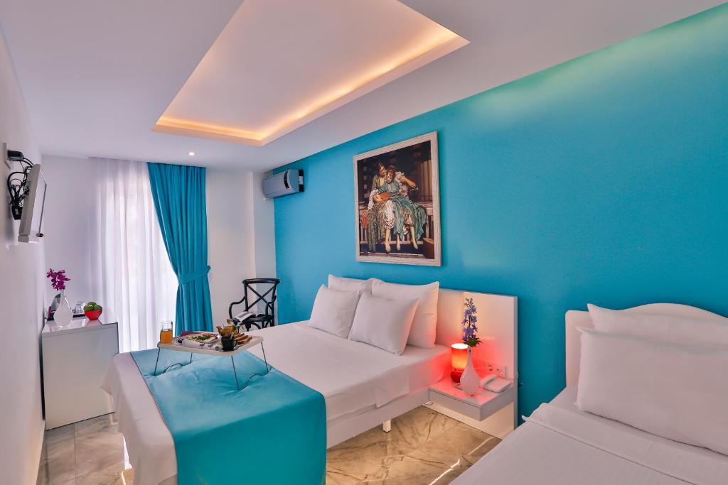 伊斯坦布尔奥塔科伊贝莱扎酒店的蓝色的卧室设有白色的床和蓝色的墙壁