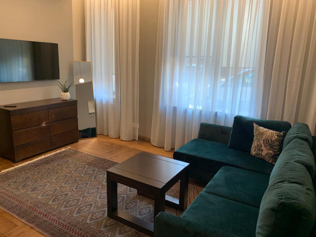 考纳斯Cathedral Apartments的客厅配有绿色沙发和茶几