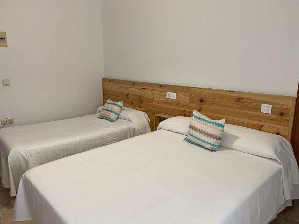 巴尔巴特巴尔巴特旅馆的配有白色床单和蓝色枕头的客房内的两张床