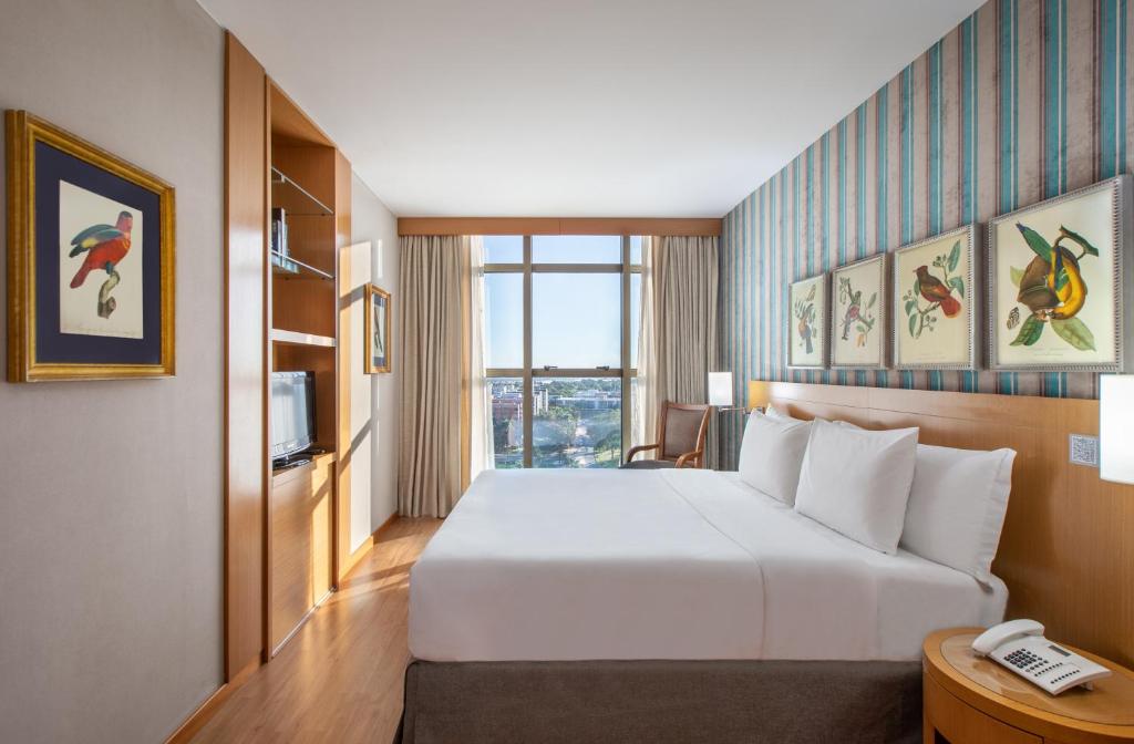 巴西利亚Brasil 21 Suites Affiliated by Meliá的酒店客房配有白色的床和电话
