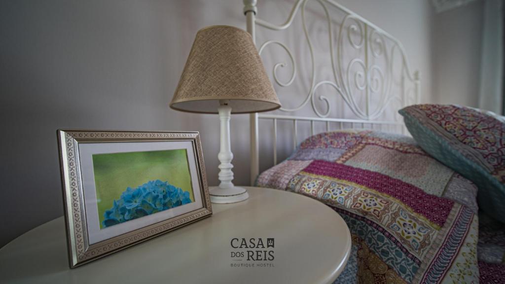 英雄港Casa Dos Reis - Boutique Hostel的一张桌子,上面画着一张照片,放在床边
