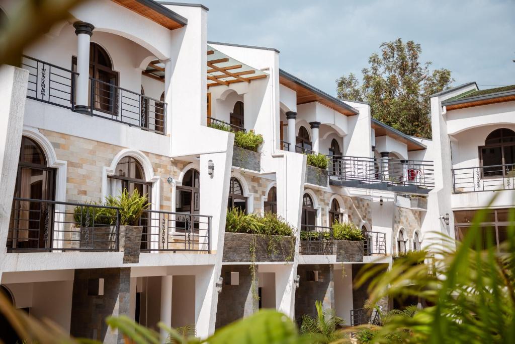 基加利Ndaru Luxury suites的阳台上一排种有植物的白色建筑