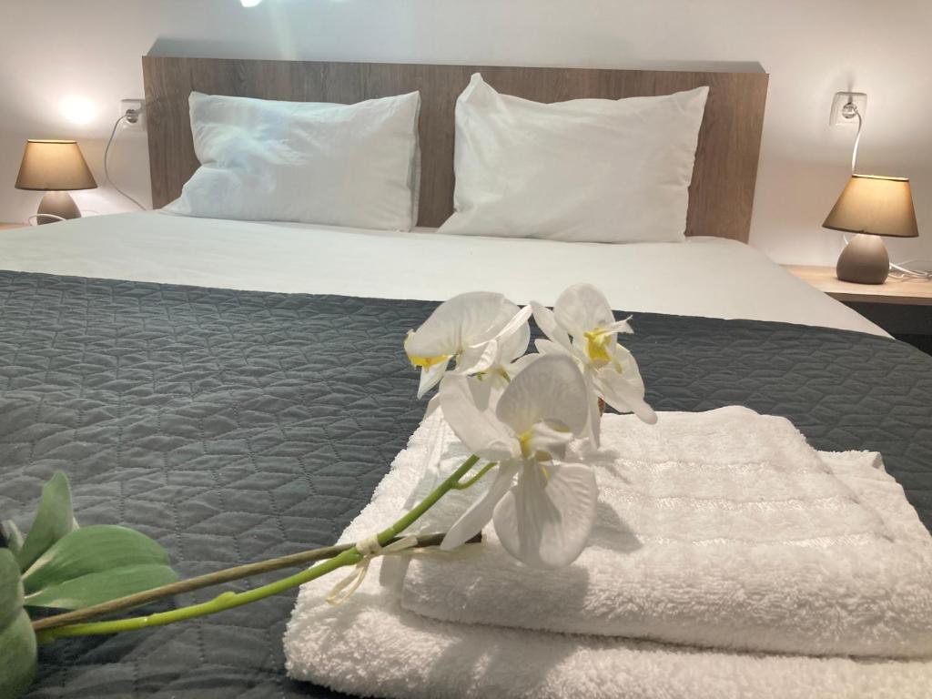 索波特Къща за гости Мегдана的酒店客房,配有带白色毛巾和鲜花的床