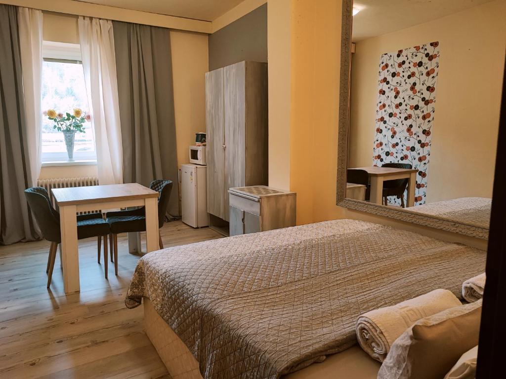 赫任斯科Penzion Přívoz的酒店客房设有两张床、一张桌子和镜子