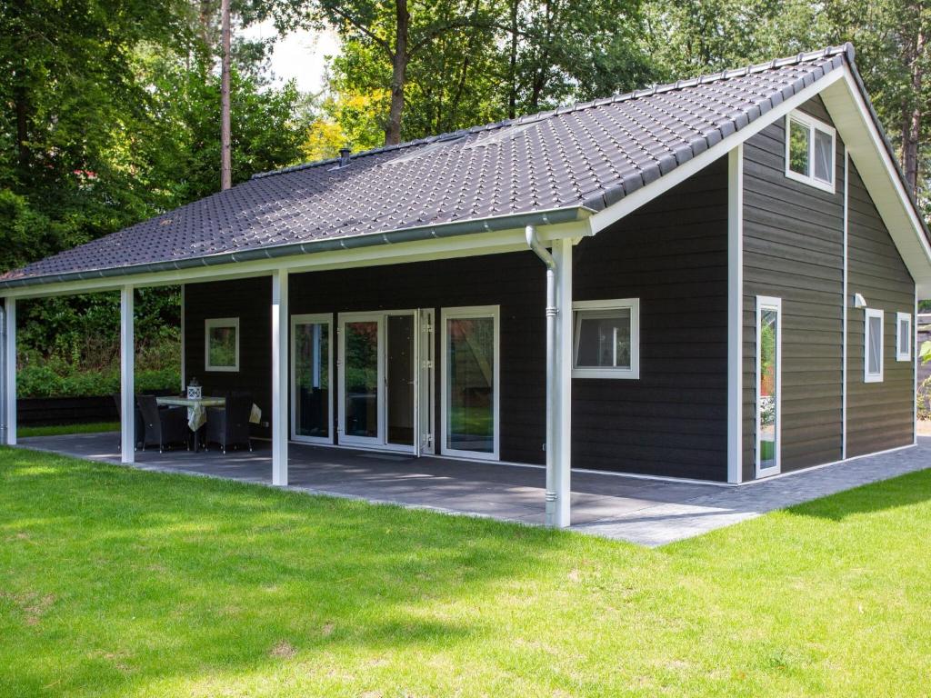 雷嫩Spacious house with covered terrace, located on a holiday park in Rhenen的大型黑色房屋设有大型天井。