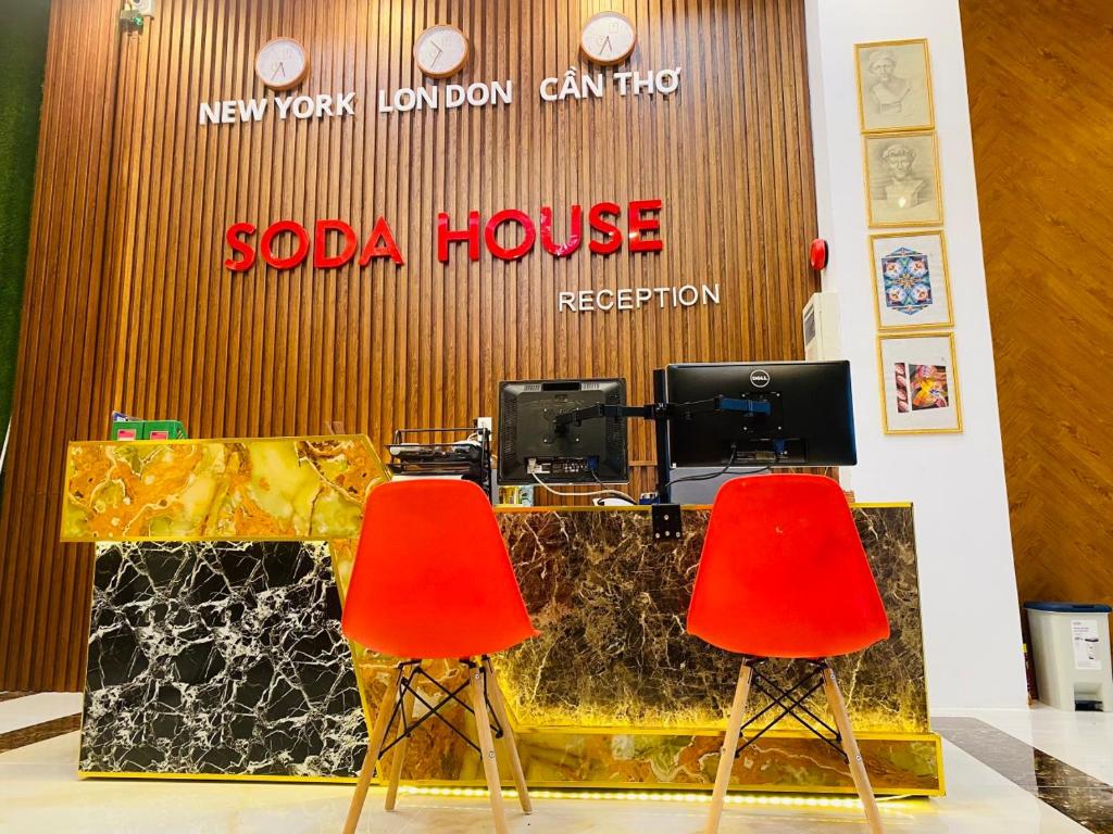 芹苴Soda House Cần Thơ的索达公寓前台前的两把红色椅子