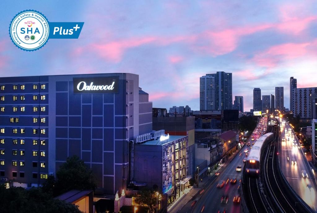 曼谷Oakwood Hotel & Residence Bangkok SHA Plus Certified的汽车在夜间欣赏城市美景
