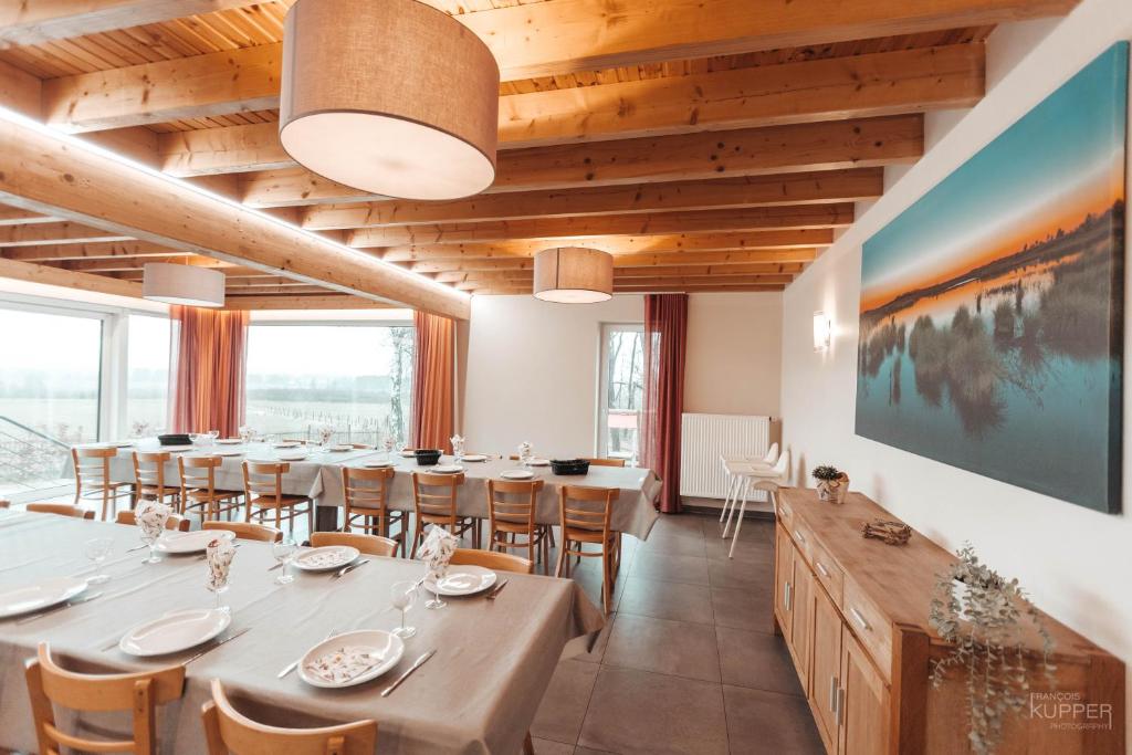 比特亨巴赫Le Loup Gris - 35 pers - Vue-Wellness, Butgenbach-Malmedy的一间带长桌和椅子的用餐室