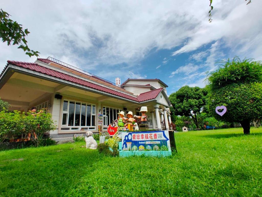 Gaoshu屏東幸福莊園庭園民宿的草上带有标志的小房子