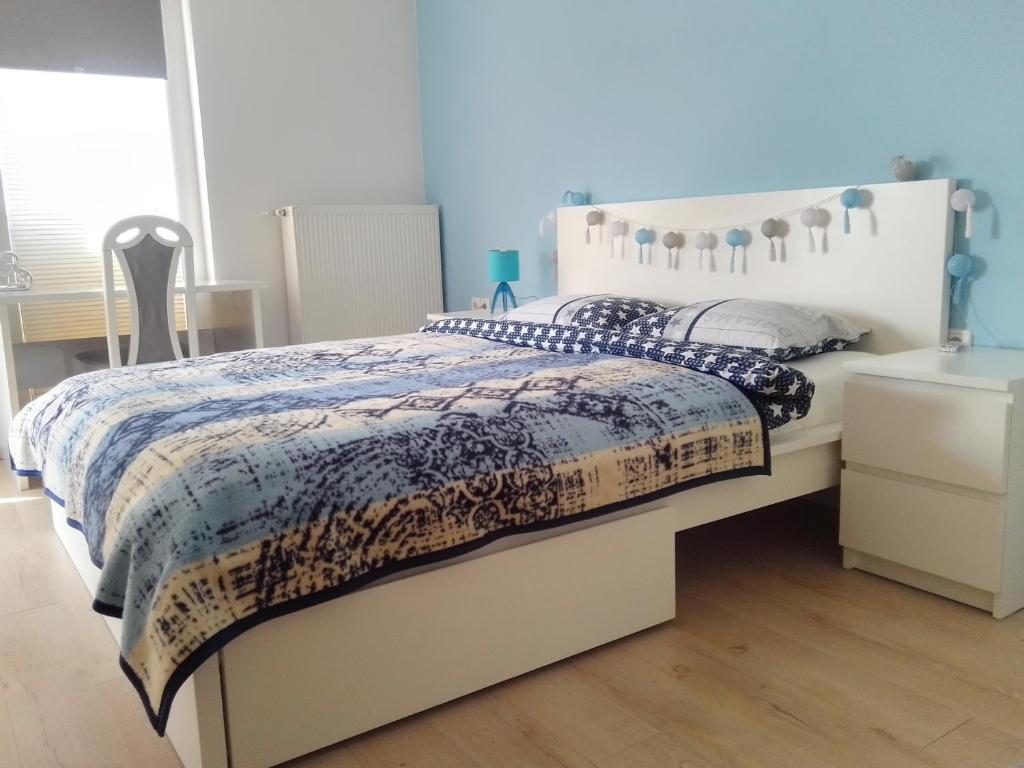 LudbregApartman Botivo的卧室配有白色床和蓝色棉被