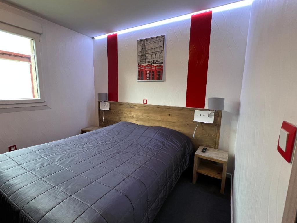 圣米耶勒德拉加勒酒店 的一间卧室设有一张床和红色及白色的墙壁