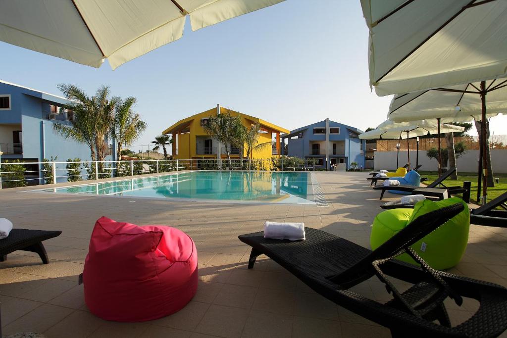 夏卡圣马可度假屋的毗邻度假酒店的带躺椅和椅子的游泳池