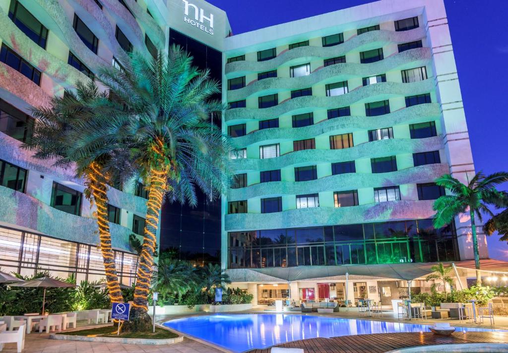 卡利卡利皇家NH酒店 的一座建筑前有棕榈树的酒店