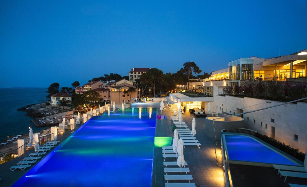 大洛希尼彭塔酒店的一座大型的游泳池,晚上与大海相连