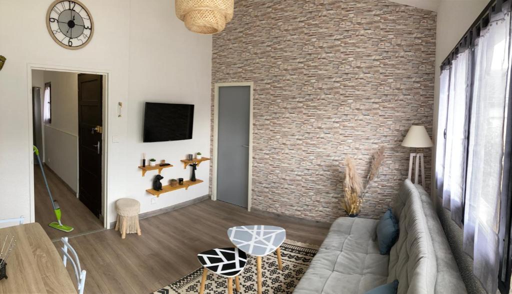 维莱福尔Petite maison VILLEFORT的带沙发和砖墙的客厅