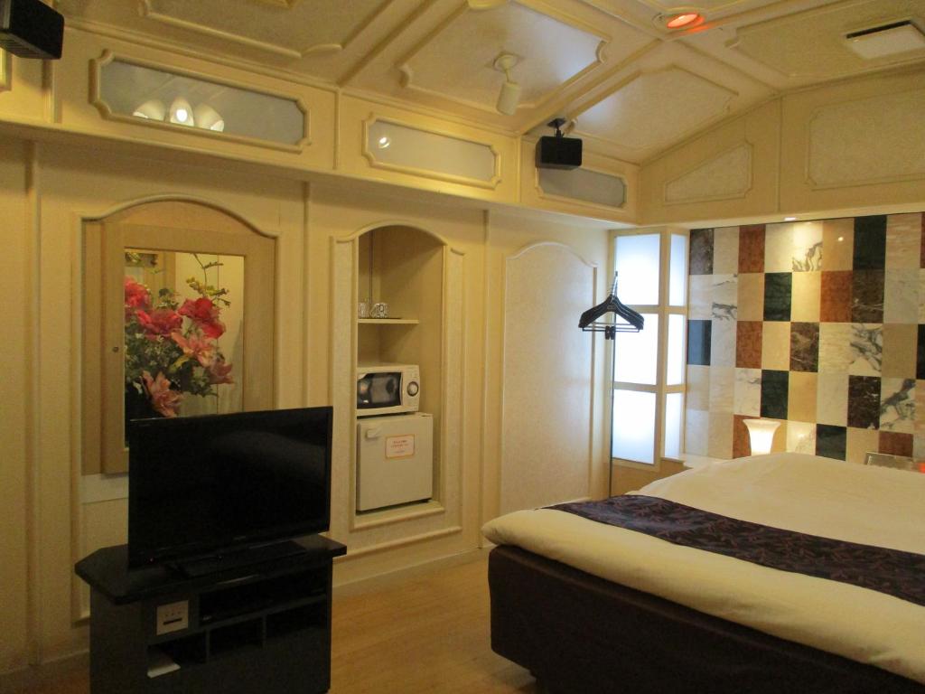 Ginanホテルハンズ的一间卧室配有一张床和一台平面电视