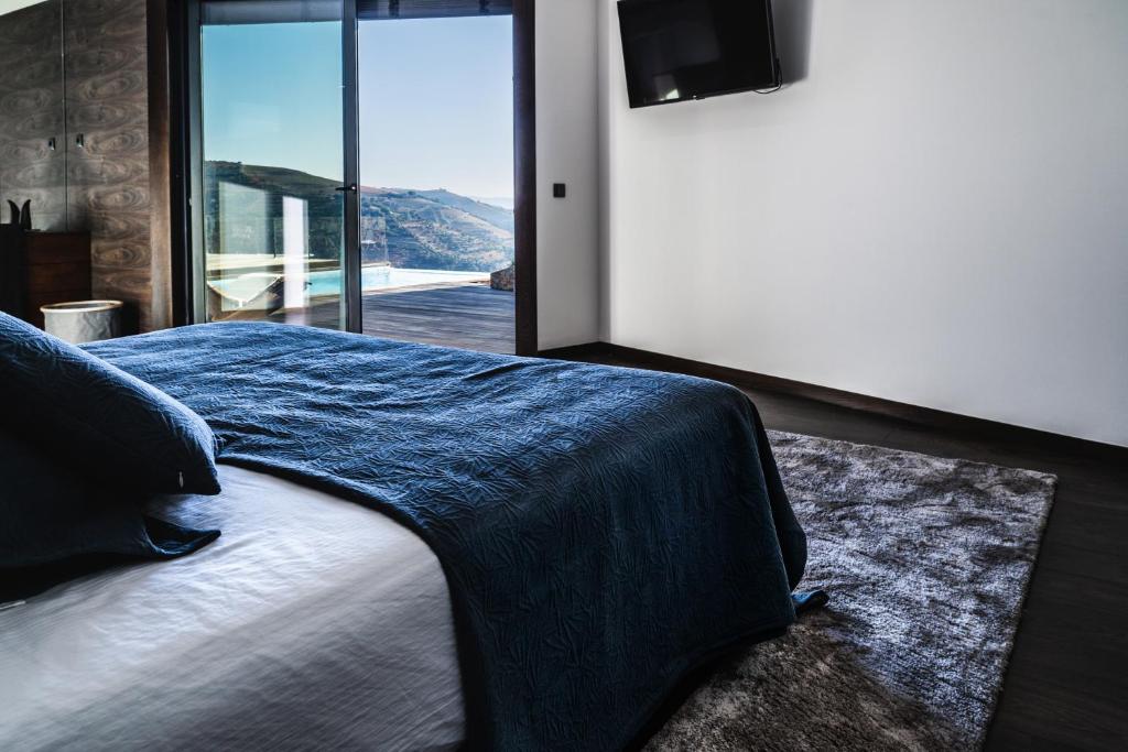 梅桑弗里乌O Pouso dos Pousos的一间卧室配有一张带蓝色毯子的床和窗户。