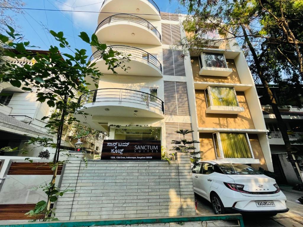 班加罗尔Sanctum Suites Indiranagar Bangalore的停在大楼前的白色汽车