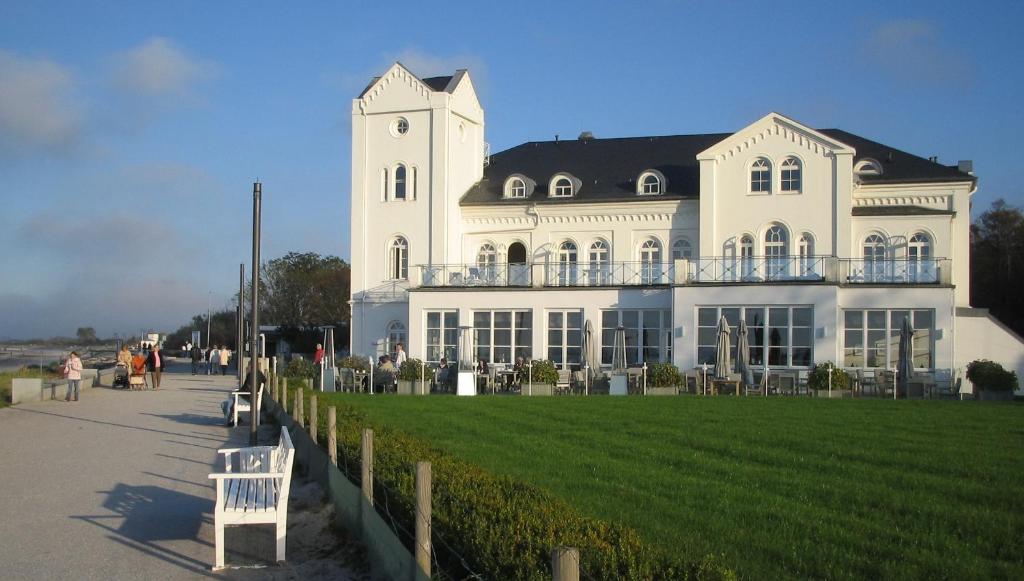 海利根达姆Haus Bischofsstab - Ferienwohnung am Meer的前面有草坪的白色大建筑