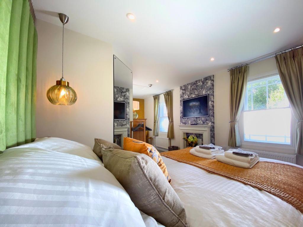 坎特伯雷Hambrook House Canterbury - NEW luxury guest house with ESPA Spa complex的卧室配有带绿色窗帘的大型白色床