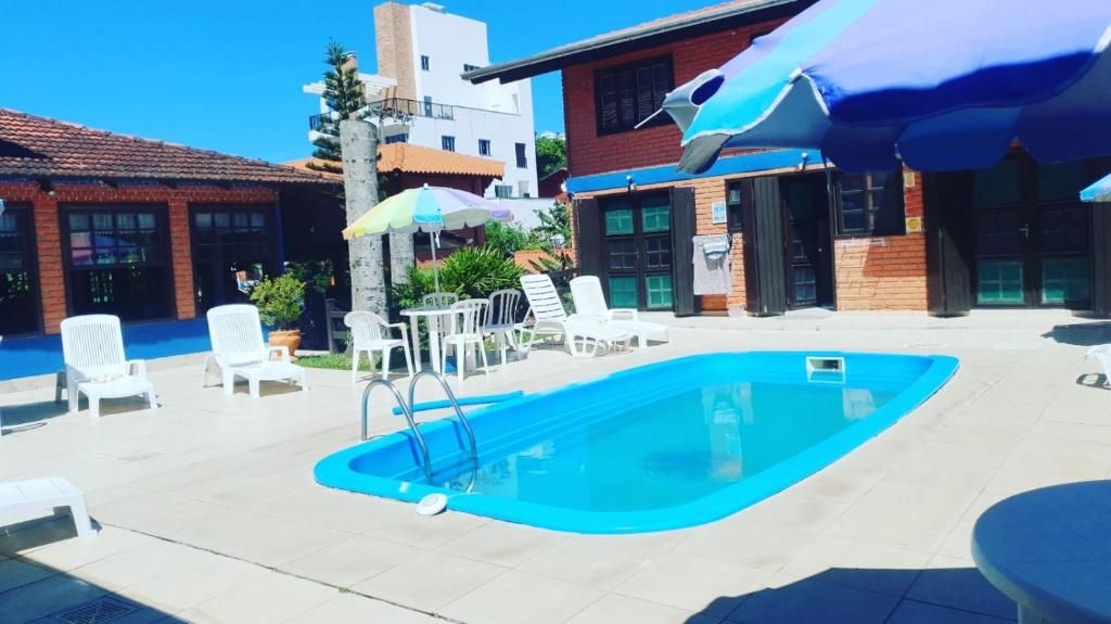邦比尼亚斯Sunshine Residencial的一个带椅子和遮阳伞的游泳池