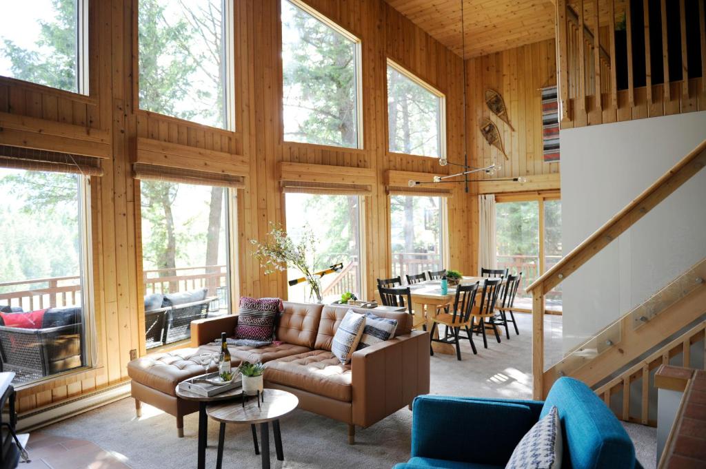 因弗米尔Mid Century Modern Mountain Cabin的客厅配有沙发、桌子和窗户