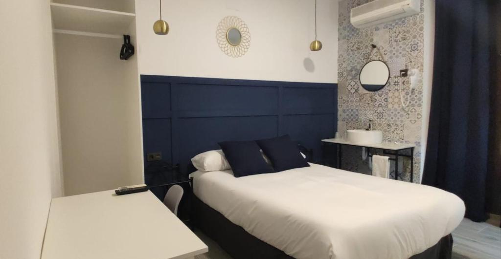 格拉纳达ROOMS Los MONTES的一间卧室设有两张床和蓝色的墙壁