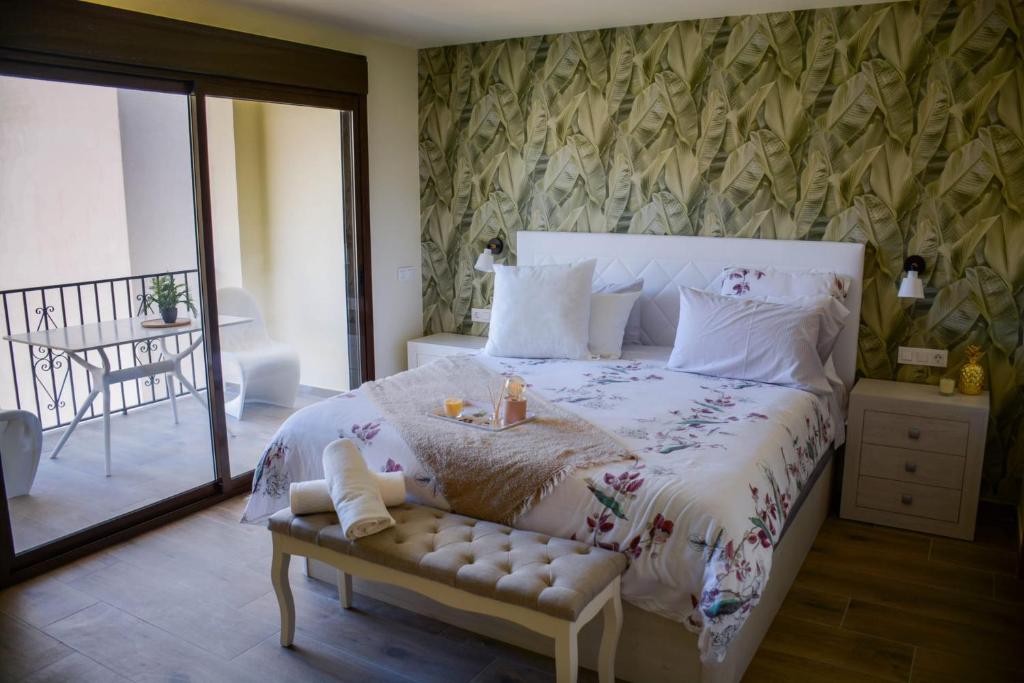 瓜达莱斯特El Tossal的卧室配有一张白色大床和长凳