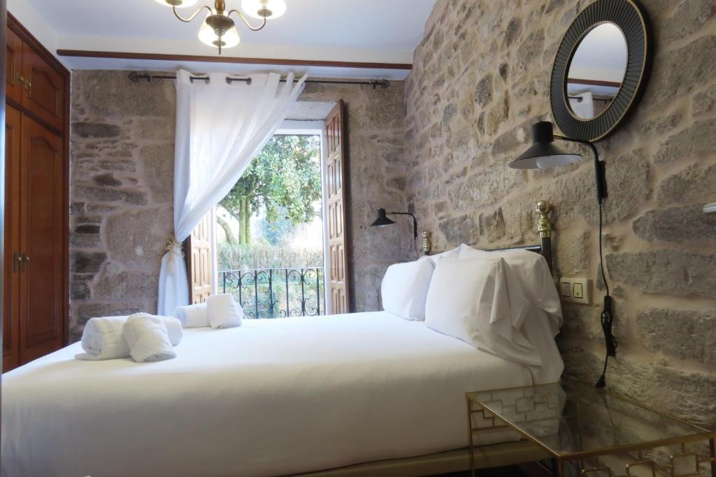 圣地亚哥－德孔波斯特拉Sete Artes by Como en Casa的卧室设有一张白色大床和一扇窗户。