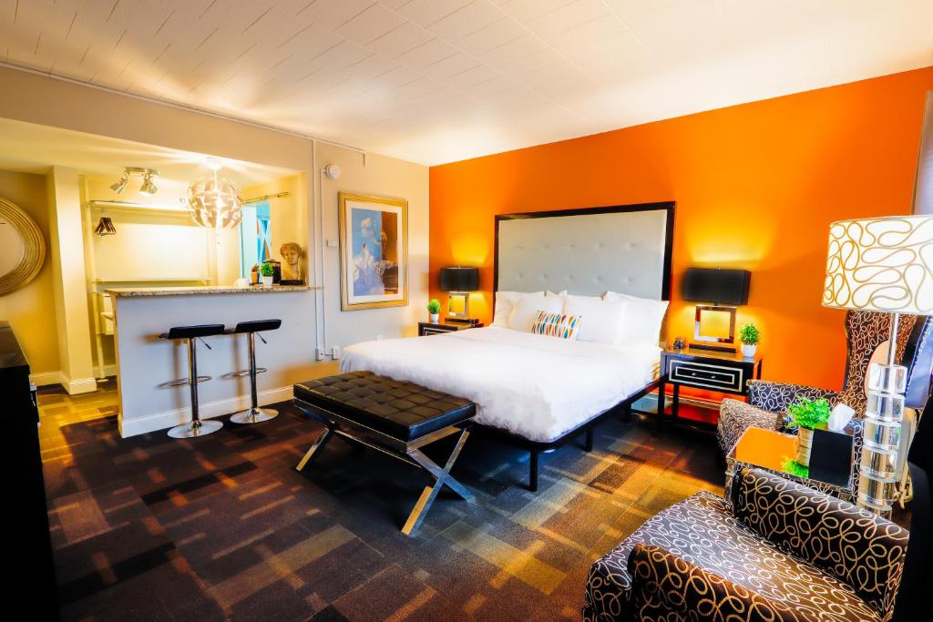 皇家橡皇家橡树汽车旅馆的卧室设有白色大床和橙色墙壁
