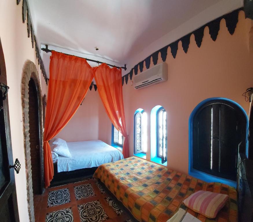 舍夫沙万达累佐曼住宿加早餐旅馆的一间卧室配有两张床和橙色窗帘
