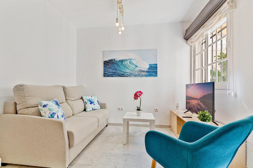 福恩吉罗拉Apartamentos a 1 minuto de la playa的客厅配有沙发和2把蓝色椅子