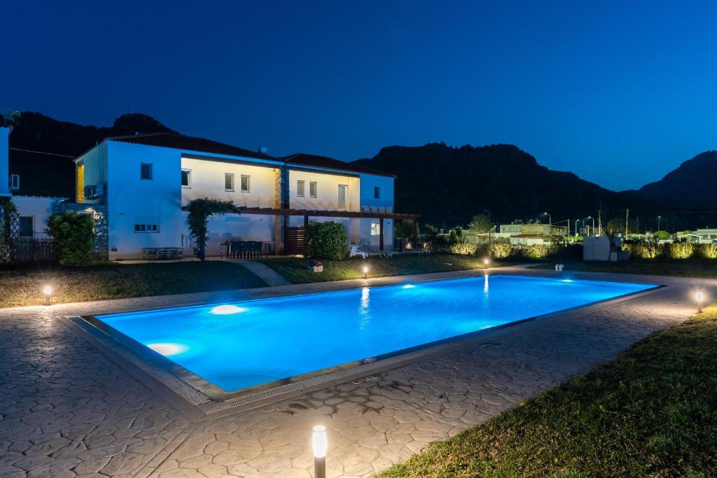 科林比亚Villa Christalia的夜间在房子前面的游泳池