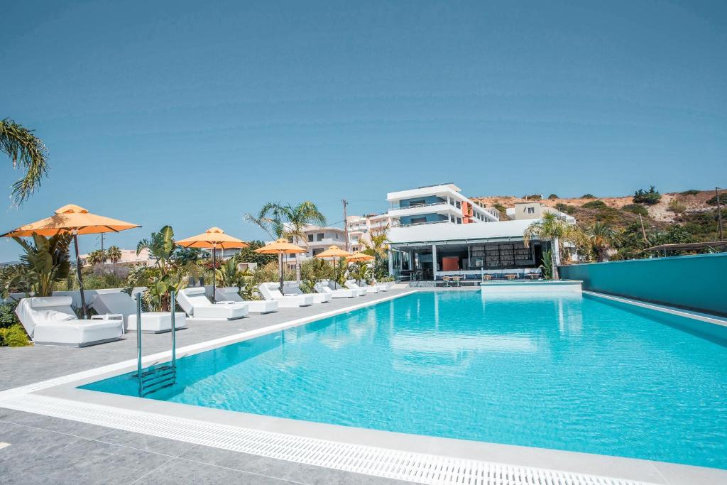 法里拉基Mazoren Art Hotel的一个带椅子和遮阳伞的大型游泳池