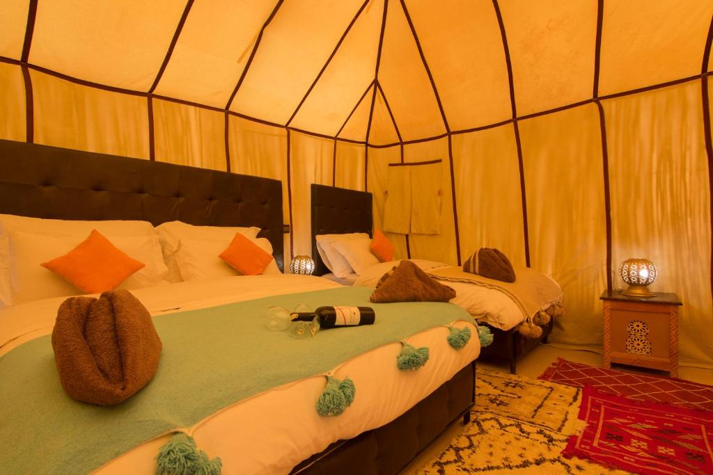 AdrouineSunset luxury camp的一间帐篷内带两张床的卧室