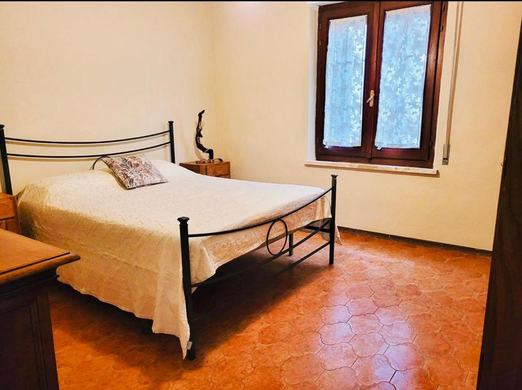 塔拉莫内Da Allegro al mare的一间卧室设有一张床和一个窗口